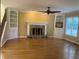 Open living room with hardwood floors, stone fireplace, built-in cabinets, and a ceiling fan at 863 Fairwood Pointe Nw, Acworth, GA 30101