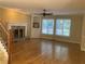 Cozy living room featuring hardwood floors, a fireplace with stone surround, and built-in shelving at 863 Fairwood Pointe Nw, Acworth, GA 30101