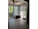 Bright sunroom with large windows, neutral walls, wood floors, ceiling fan, and a round ottoman at 1504 Augusta Se Dr, Marietta, GA 30067