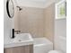 Bathroom featuring a white vanity with black fixtures and a shower with large, square, neutral-toned tiling at 1728 Line St, Decatur, GA 30032