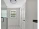 Bright bathroom featuring a glass shower, hexagon tile flooring, a window, and a white door at 1728 Line St, Decatur, GA 30032