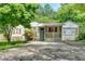 Lovely one-story home boasts a cozy front porch, stone accents, and a large driveway, nestled among mature trees and shrubs at 1728 Line St, Decatur, GA 30032