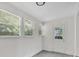 Bright room with gray wood-look floors, white walls, three windows and a white door at 1728 Line St, Decatur, GA 30032