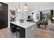 Open-concept kitchen featuring a large island with seating, sleek black cabinets, and hardwood floors at 946 Hughley Circle # 98, Atlanta, GA 30316