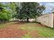 Large backyard with mature trees, a storage shed, and a classic wooden fence at , Tucker, GA 30084