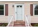 Charming front door with white trim, matching storm door, and decorative railing at , Tucker, GA 30084