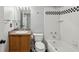 Compact bathroom with a bathtub-shower, oak vanity, and a black and white tile accent at 1151 Goodwin Ne Rd, Brookhaven, GA 30324