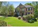 Charming two-story brick home with manicured lawn, lush landscaping, and black shutters at 1151 Goodwin Ne Rd, Brookhaven, GA 30324