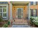 Elegant front door with sidelights and brick steps flanked by manicured bushes and lighting at 1151 Goodwin Ne Rd, Brookhaven, GA 30324