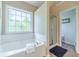 Modern bathroom featuring a soaking tub, walk-in shower, and large window at 1356 Belfaire Trce, Dacula, GA 30019