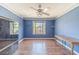 Blue bedroom with hardwood floors, a large window, and ample closet space at 1356 Belfaire Trce, Dacula, GA 30019