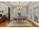 Traditional dining room featuring a wooden table, chandelier, and views of nature at 1420 Lockridge Dr, Cumming, GA 30041