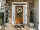 Charming front door with stone surround, decorative wreath, and sidelights at 1420 Lockridge Dr, Cumming, GA 30041