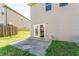 Side view of backyard with concrete patio and a partial view of the adjacent house at 2142 Theberton Trl, Locust Grove, GA 30248