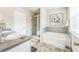 Bright bathroom featuring a double vanity, soaking tub, walk-in shower, and tile flooring at 2142 Theberton Trl, Locust Grove, GA 30248