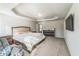 Bright bedroom with a tray ceiling, TV on the wall, carpet flooring, and lots of natural light at 2142 Theberton Trl, Locust Grove, GA 30248