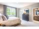 Beautiful bedroom with bright window and dark dresser that leads to attached bath at 4725 Montane St, Cumming, GA 30028