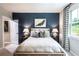 Cozy bedroom features a king size bed with a dark blue accent wall and bright window at 4725 Montane St, Cumming, GA 30028