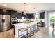 Bright, modern kitchen features an island with seating, dark cabinets, stainless steel appliances, and ample counter space at 4725 Montane St, Cumming, GA 30028