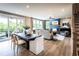 Open-concept living and dining area with hardwood floors, a fireplace, and access to an outdoor deck at 4725 Montane St, Cumming, GA 30028
