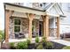 Warm front porch featuring sturdy wooden posts, elegant seating, and neat landscaping at 4725 Montane St, Cumming, GA 30028