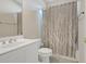 Cozy bathroom featuring white vanity, toilet, and a shower-tub combo with a patterned curtain at 5177 Cabot Creek Dr, Buford, GA 30518