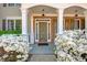 Inviting front porch with classic columns, decorative brickwork, and blooming white azalea bushes at 5177 Cabot Creek Dr, Buford, GA 30518