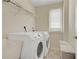 Bright laundry room featuring a washer, dryer, storage cabinets, and wire shelving at 5177 Cabot Creek Dr, Buford, GA 30518