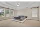 Spacious primary bedroom with neutral carpet, tray ceiling, and large windows at 5177 Cabot Creek Dr, Buford, GA 30518
