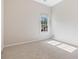 An empty bedroom has neutral walls, carpet, and natural light from a large window at 660 Gran Heritage Way, Dacula, GA 30019