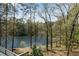 Lush backyard with a view of the serene lake and mature trees at 9055 Carroll Manor Dr, Sandy Springs, GA 30350