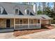 Charming home showcasing a blend of stone and brick accents with a welcoming front porch and manicured landscaping at 9055 Carroll Manor Dr, Sandy Springs, GA 30350