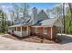 Spacious home boasts a brick and stone exterior with a wraparound porch and a convenient carport at 9055 Carroll Manor Dr, Sandy Springs, GA 30350
