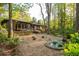 Beautiful backyard with a stone patio, water feature, lush landscaping, and the home's exterior at 1850 Winchester Trl, Brookhaven, GA 30341