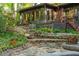 Backyard with stone retaining walls, multiple stairs, lush landscaping, and brick/stone patio at 1850 Winchester Trl, Brookhaven, GA 30341