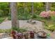 Backyard patio with stone table, lush landscaping and brick surround at 1850 Winchester Trl, Brookhaven, GA 30341