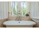 Bathroom featuring a classic clawfoot tub positioned by a window with natural light and decorative finishes at 1850 Winchester Trl, Brookhaven, GA 30341