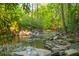 Peaceful creek flowing through a lush forest with large rocks and natural beauty at 1850 Winchester Trl, Brookhaven, GA 30341