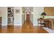 Hallway with polished hardwood floors, featuring a glimpse of the kitchen and the home's front entry door at 1850 Winchester Trl, Brookhaven, GA 30341