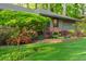 Landscaped front yard boasting a well-maintained lawn, vibrant flowers, and a charming brick-lined garden bed at 1850 Winchester Trl, Brookhaven, GA 30341