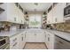 Galley kitchen featuring bright white cabinets, modern hardware, stainless appliances and tile backsplash and floors at 1850 Winchester Trl, Brookhaven, GA 30341