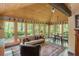 Cozy sunroom features wood ceilings, walls of windows, and a comfortable seating area, creating a relaxing space at 1850 Winchester Trl, Brookhaven, GA 30341