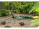 Charming backyard water feature with stone surround and lush landscaping, perfect for relaxation at 1850 Winchester Trl, Brookhaven, GA 30341