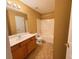 Well-lit bathroom featuring a vanity with wood cabinets and shower-tub combo at 445 Pintail Ct, Suwanee, GA 30024