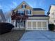 Two-story home with stone accents and a two-car garage, complemented by a well-maintained yard and mature landscaping at 445 Pintail Ct, Suwanee, GA 30024