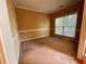 Empty room with neutral paint, large window with blinds, and carpeted floors at 445 Pintail Ct, Suwanee, GA 30024