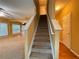Stairway leading up to the second floor, with a view of the living area and its natural light at 445 Pintail Ct, Suwanee, GA 30024