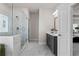 Bright bathroom featuring marble-style tiling, glass shower, and vanity with a dark-gray cabinet at 627 Skytop Dr, Cumming, GA 30040