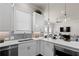 Well-lit kitchen with herringbone backsplash, white cabinets and quartz countertops and stainless dishwasher at 627 Skytop Dr, Cumming, GA 30040