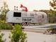 Tin Cup Grill food truck featuring a putt-putt arrow sign, a retro design, and inviting outdoor seating in a playful setting at 627 Skytop Dr, Cumming, GA 30040